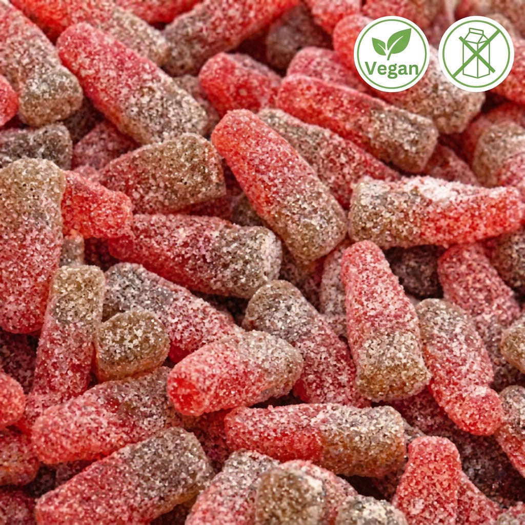A close-up of small, red and green colored candy bottles with a sugar coating, resembling cherry cola bottles.